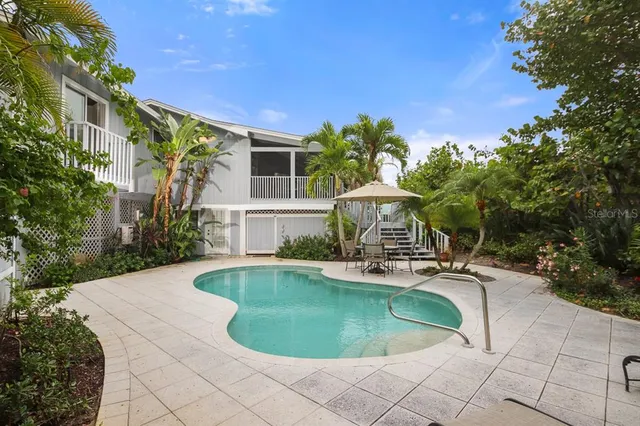 a view of a house with swimming pool and sitting area