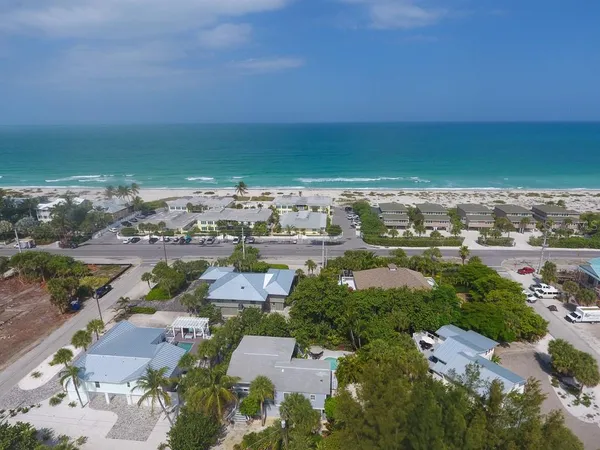 an aerial view of a city with lots of residential buildings and ocean view in back