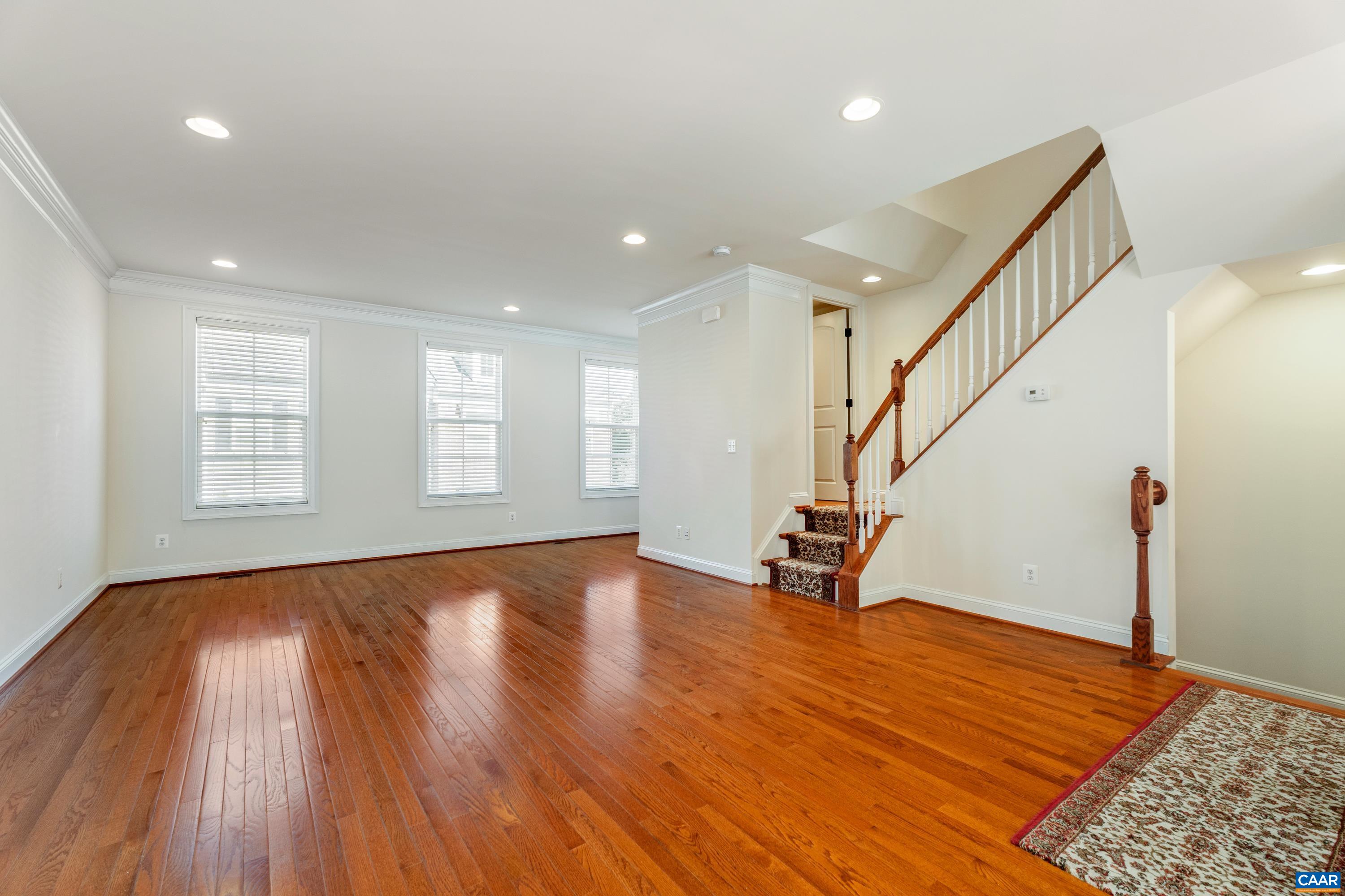 408 Samara Court Charlottesville, VA 22903 - Photo 13 of 44 a view of an empty room with wooden floor and stairs