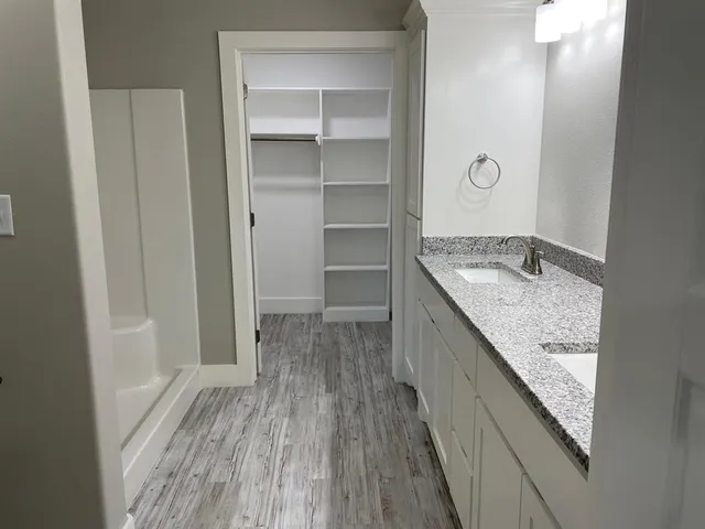 a bathroom with a granite countertop sink a vanity and shower
