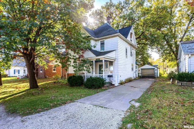 a front view of a house with a yard and trees