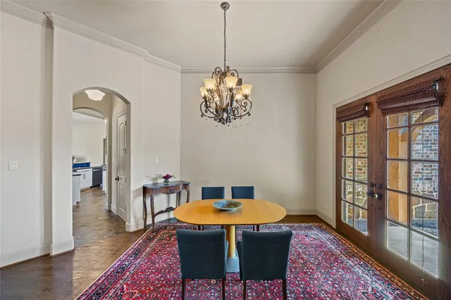 a dining room with a table or chandelier and wooden floor