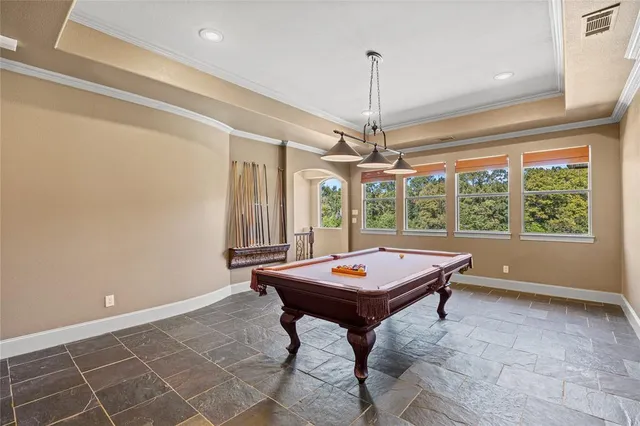 a room with pool table and windows