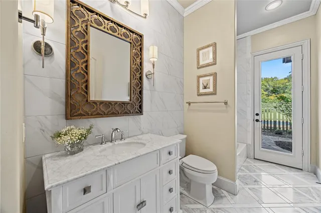 a bathroom with a granite countertop toilet sink and mirror