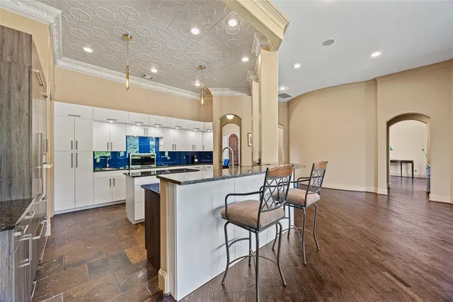 a kitchen with stainless steel appliances granite countertop a stove a sink a refrigerator dining table and chairs