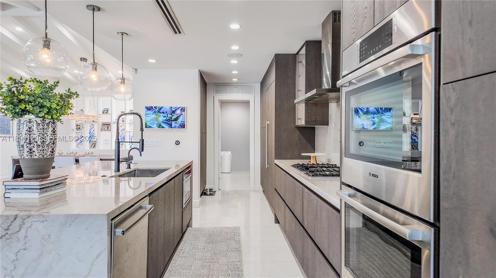 12855 Maple Road North Miami, FL 33181 - Photo 16 of 51 a large kitchen with stainless steel appliances kitchen island granite countertop a sink and cabinets