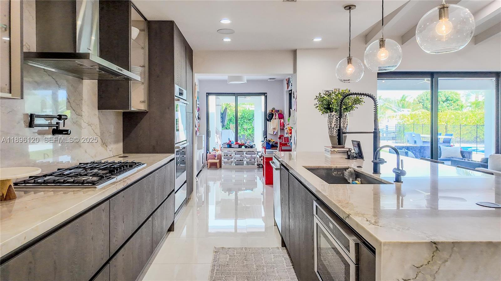 12855 Maple Road North Miami, FL 33181 - Photo 18 of 51 a kitchen with stainless steel appliances granite countertop a sink a stove and a wooden floors