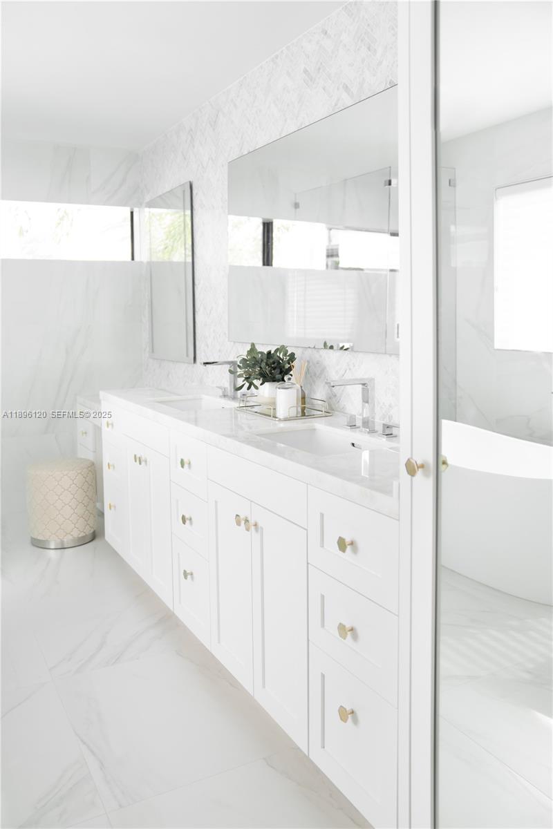 12855 Maple Road North Miami, FL 33181 - Photo 27 of 51 a bathroom with a double vanity sink a mirror and a bathtub