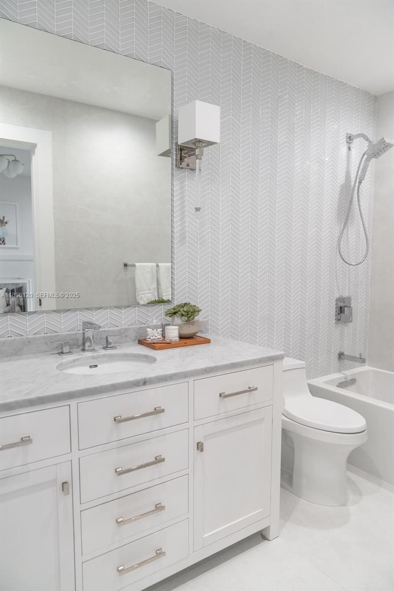 12855 Maple Road North Miami, FL 33181 - Photo 33 of 51 a bathroom with a granite countertop sink a toilet and a mirror