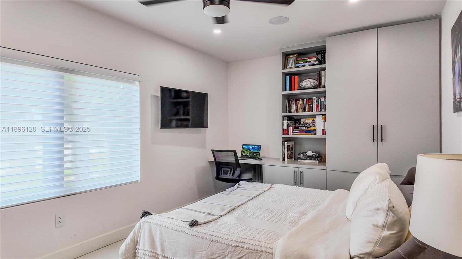 12855 Maple Road North Miami, FL 33181 - Photo 38 of 51 a bedroom with a bed and a book shelf