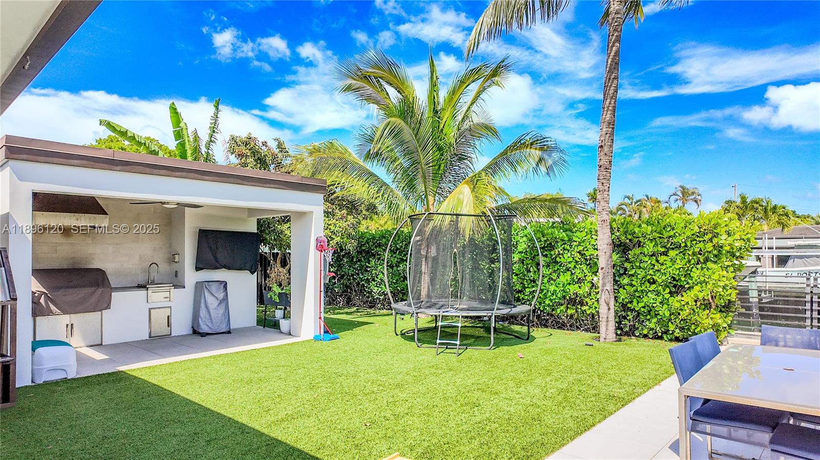 12855 Maple Road North Miami, FL 33181 - Photo 41 of 51 a view of a chair and tables in the patio with a yard
