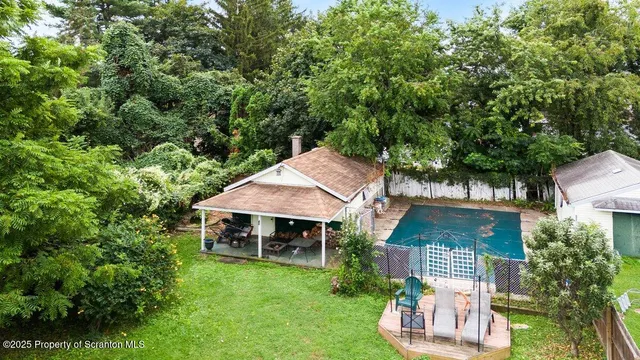 an aerial view of a house with swimming pool and garden
