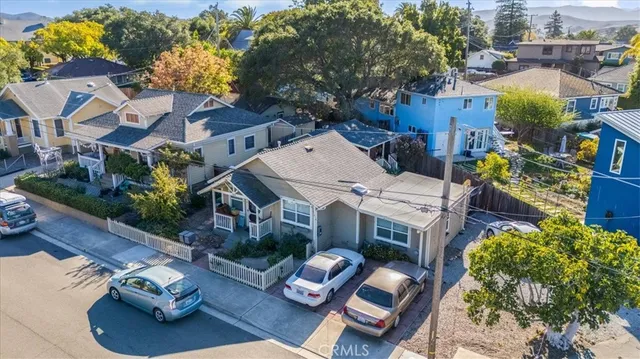 an aerial view of residential houses with outdoor space and trees