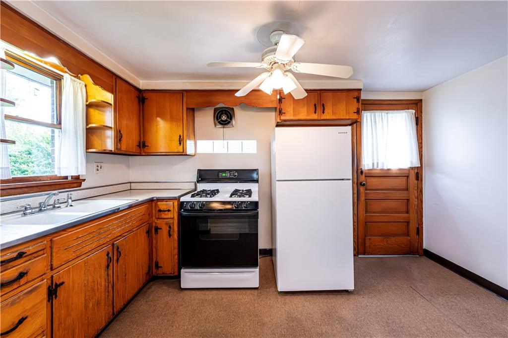 13740 Ridge Road Irwin, PA 15642 - Photo 11 of 43 a kitchen with stainless steel appliances granite countertop a refrigerator a stove a sink and a window