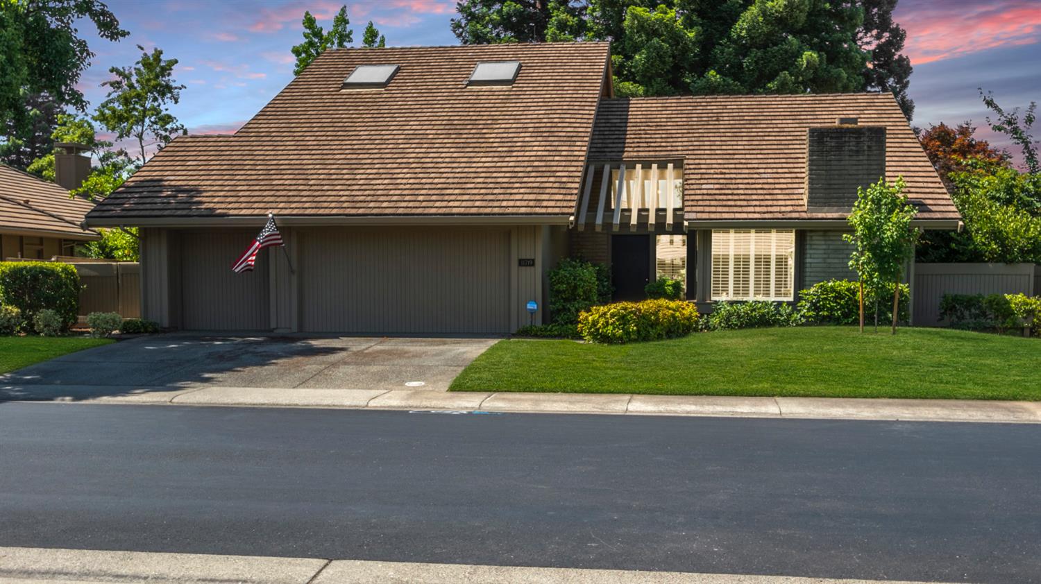 a front view of a house with a garden and plants