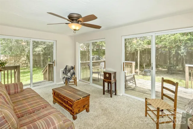 a living room with furniture and a large window with balcony view