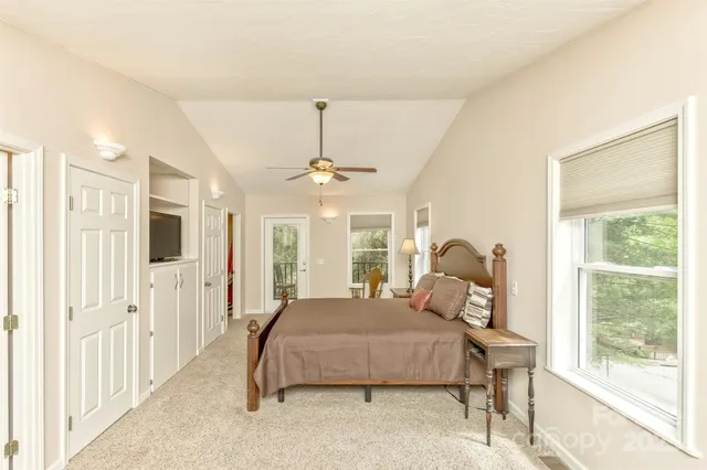 a bedroom with a bed mirror and window
