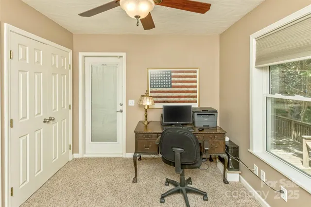 a view of a workspace with furniture and a window