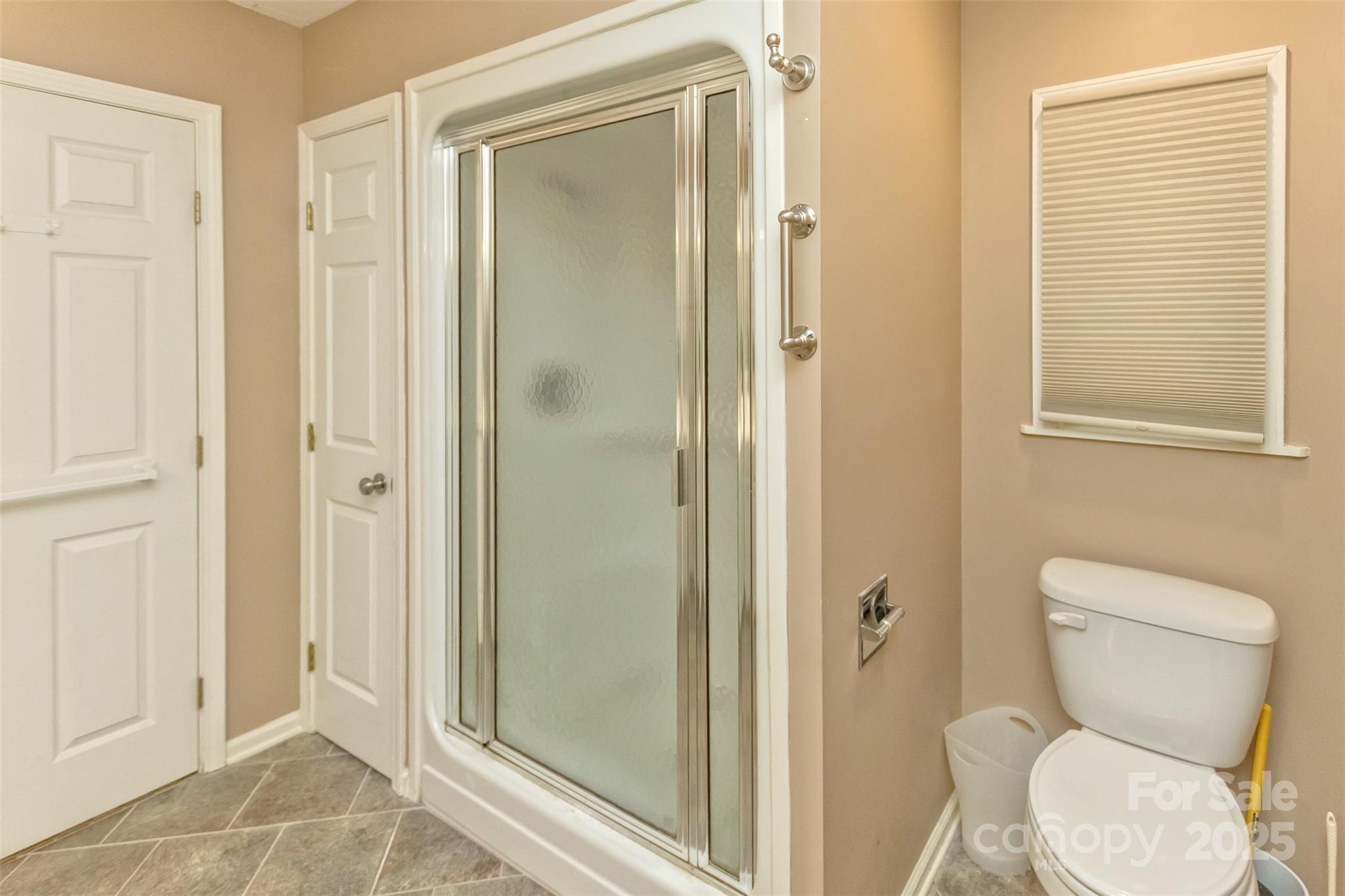15 Beaverdam Knoll Road Asheville, NC 28804 - Photo 20 of 39 a bathroom with a toilet shower and a window