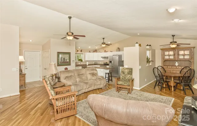 a living room with furniture a dining table and a chandelier