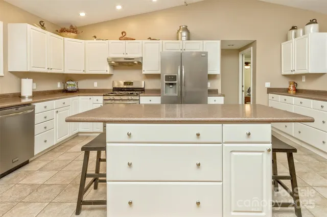 a kitchen with stainless steel appliances granite countertop white cabinets and white appliances