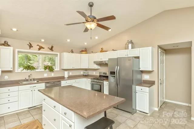 a kitchen with a refrigerator a sink and cabinets