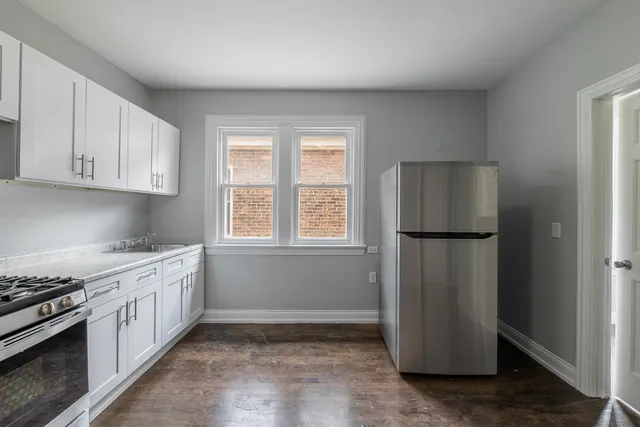 a kitchen with a refrigerator sink stove and cabinets
