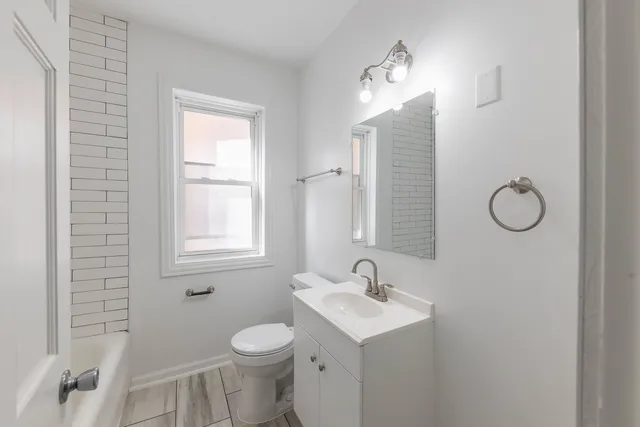 a bathroom with a toilet sink and mirror