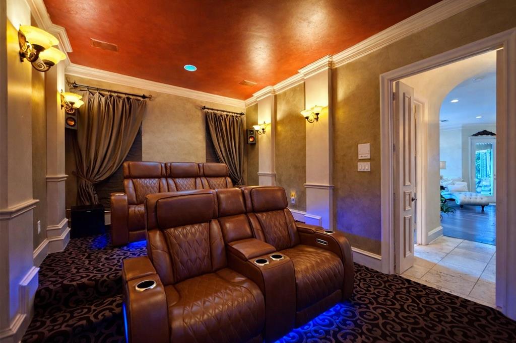 1919 Kings Pass Heath, TX 75032 - Photo 28 of 38 Dedicated media room featuring patterned carpet, brown leather seating, and wall sconces providing ambient lighting