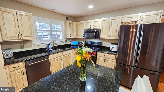 a kitchen with stainless steel appliances a refrigerator sink and microwave