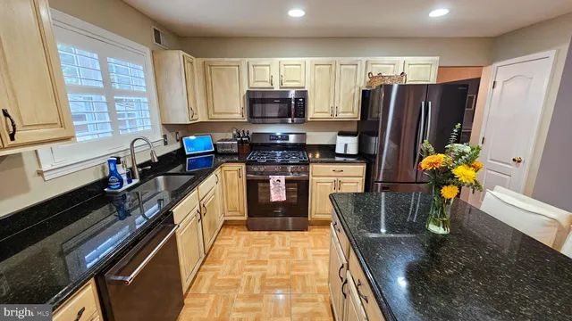 a kitchen with stainless steel appliances a sink dishwasher stove microwave and refrigerator