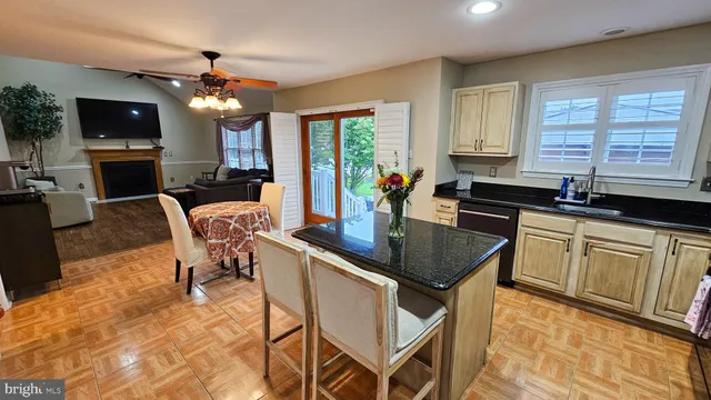 a kitchen with stainless steel appliances granite countertop a sink a stove a table and chairs