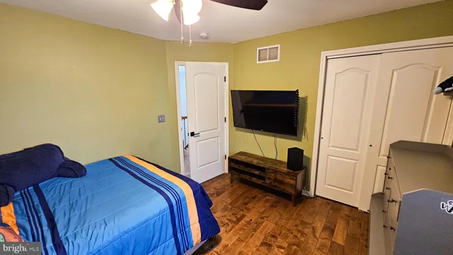 a bedroom with a bed flat screen tv and a chandelier