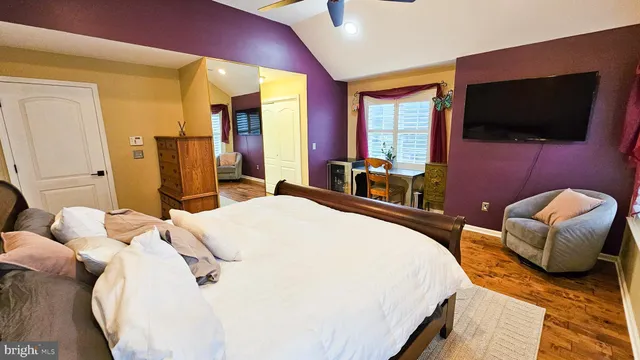 a spacious bedroom with a bed and a flat screen tv