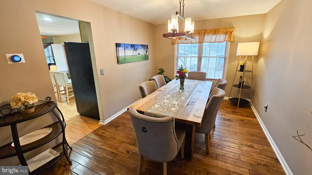 a dining room with furniture a chandelier and wooden floor