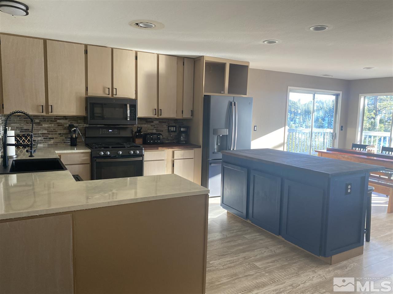 321 Barton Drive Stateline, NV 89449 - Photo 2 of 23 a kitchen with stainless steel appliances granite countertop a refrigerator a sink a stove a microwave and wooden cabinets