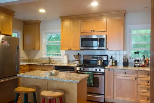 a kitchen with stainless steel appliances granite countertop a stove a sink and a microwave