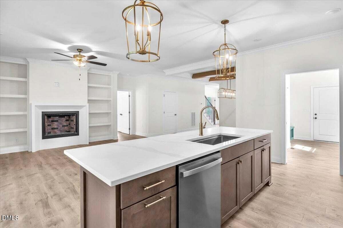 12845 Mallard Rock Road Zebulon, NC 27597 - Photo 29 of 63 a kitchen with a sink a chandelier stainless steel appliances and fireplace