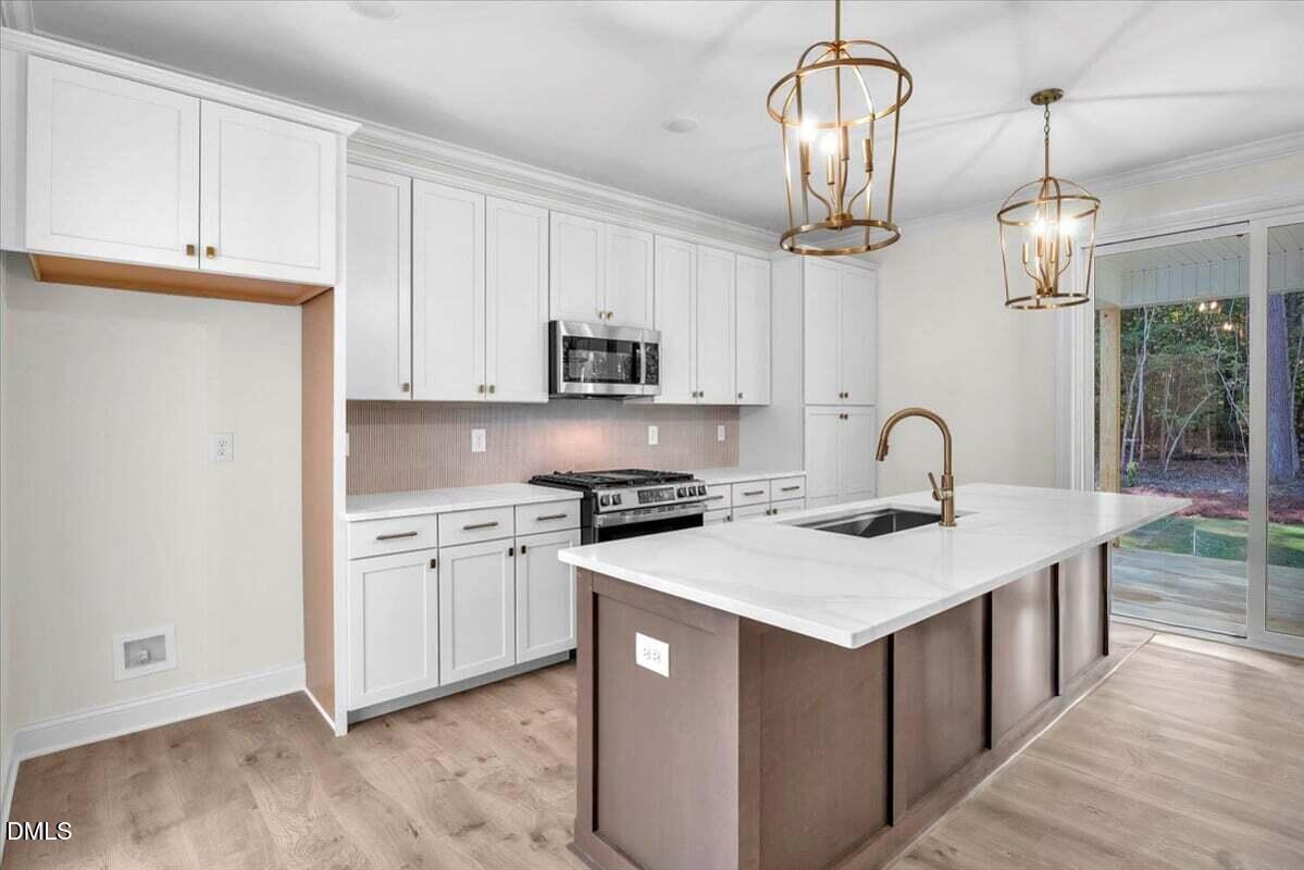 12845 Mallard Rock Road Zebulon, NC 27597 - Photo 30 of 63 a kitchen with stainless steel appliances a sink a stove a refrigerator cabinets and a window