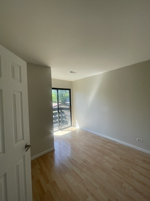 1590 Perry Court, Unit A Aurora, IL 60505 - Photo 11 of 17 an empty room with wooden floor and windows