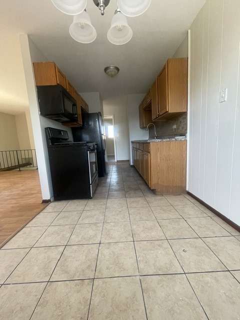 1590 Perry Court, Unit A Aurora, IL 60505 - Photo 9 of 17 a kitchen with stainless steel appliances granite countertop a refrigerator and a stove top oven