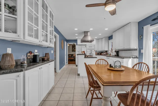 a kitchen with granite countertop kitchen island stainless steel appliances a table and chairs in it