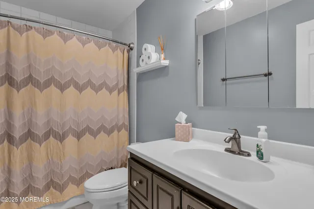 a bathroom with a sink a toilet and shower curtain