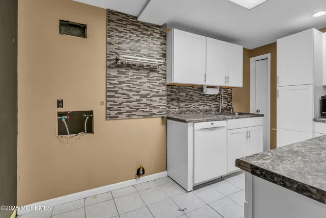 a kitchen with granite countertop white cabinets and white appliances
