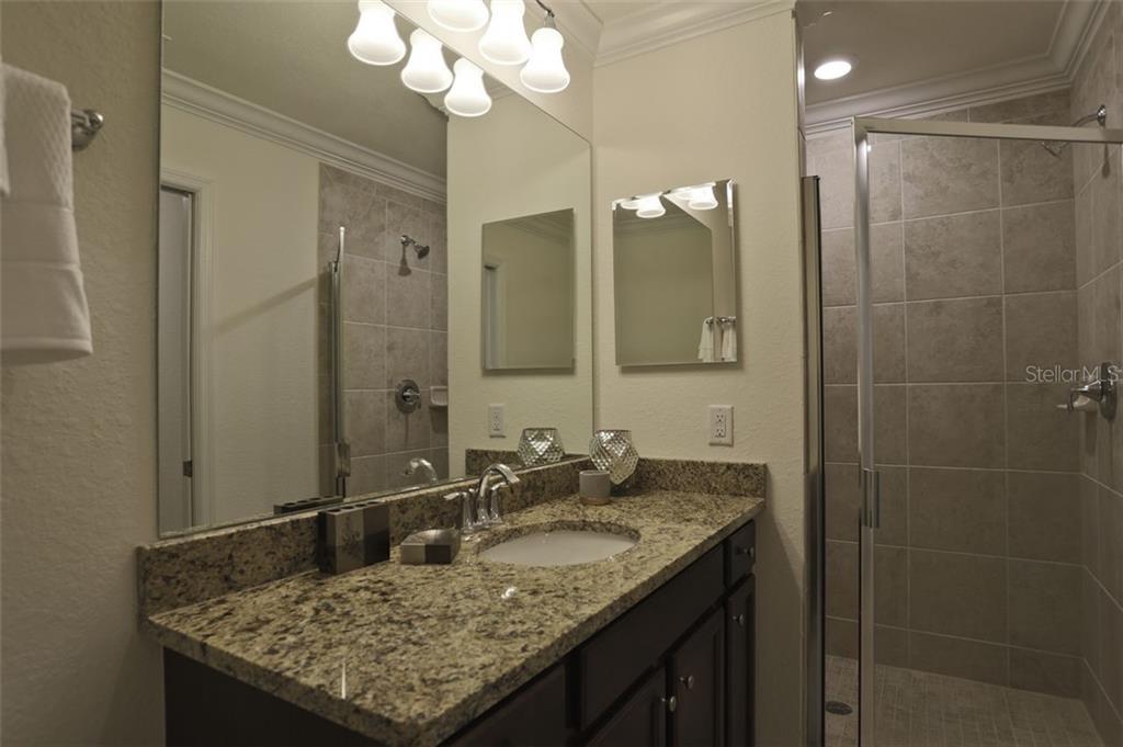 Undisclosed Address Lakewood Ranch, FL 34211 - Photo 11 of 28 a bathroom with a granite countertop sink a mirror and a shower