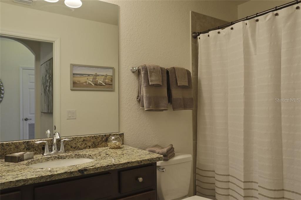 Undisclosed Address Lakewood Ranch, FL 34211 - Photo 14 of 28 a bathroom with a granite countertop sink and a mirror