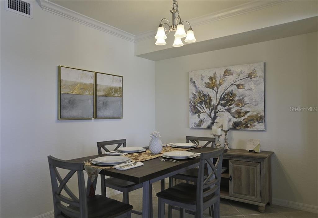 Undisclosed Address Lakewood Ranch, FL 34211 - Photo 4 of 28 a view of a dining room with furniture and wooden floor