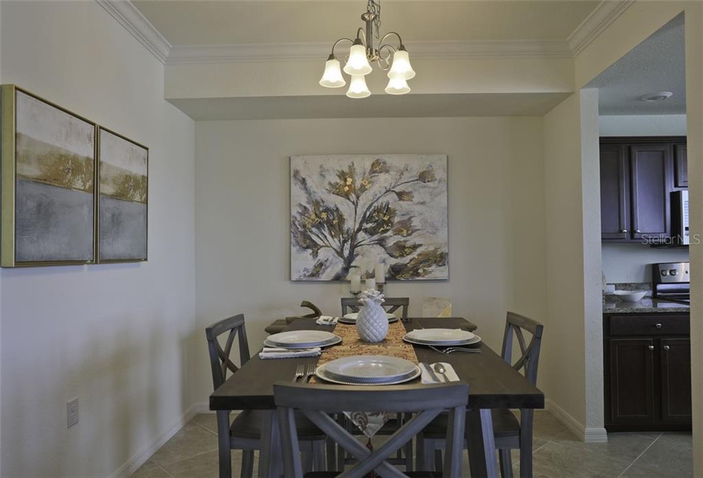 Undisclosed Address Lakewood Ranch, FL 34211 - Photo 5 of 28 a view of a dining room with furniture and wooden floor