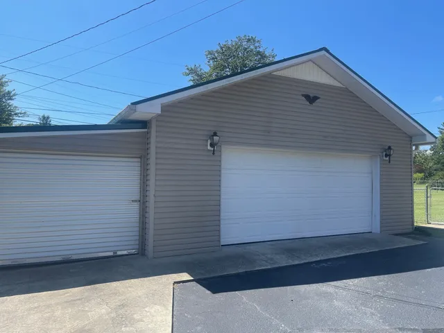 an empty room with wooden floor closet and windows