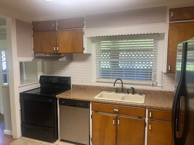 a kitchen with stainless steel appliances granite countertop a refrigerator and a sink